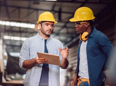 Procore help for small construction companies Procore help for small construction companies | A consultant helps an construction worker on the jobsite.