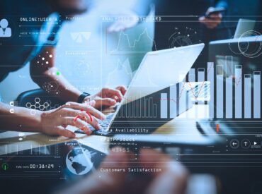A digital bar graph is superimposed over an image of someone typing on a laptop. This represents submittal management in Procore.
